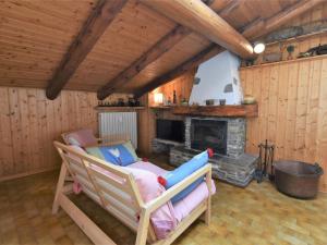 a living room with a rocking chair and a fireplace at Apartment Nido dello Stelvio by Interhome in Pezzo +16 photos