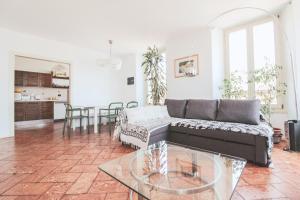 a living room with a couch and a glass table at Appartamento La Perla del Lago in Dongo