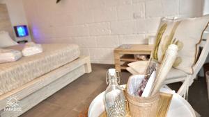 a living room with a bed and a table with bottles at Paradise Sea Terrace in Monopoli