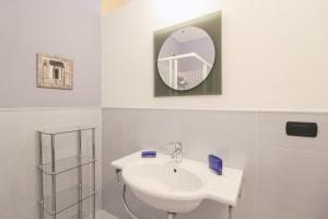 a white bathroom with a sink and a mirror at Appartamento La Perla del Lago in Dongo +13 photos