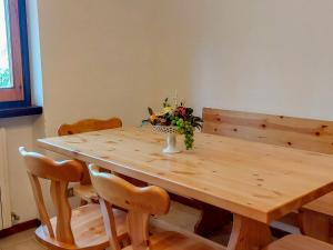 une table en bois avec un vase de fleurs dessus dans l'établissement Apartment Nel Castagneto-1 by Interhome, à Perledo