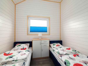 a bedroom with two beds and a window at Zakatek Baltyku - domki nad morzem i jeziorem in Jezierzany