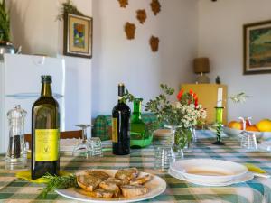 a table with two bottles of wine and a plate of food at Apartment Tramontana by Interhome in Bibbona