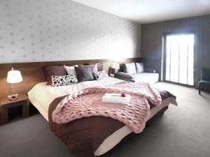 um quarto com uma cama grande e um sofá em Hotel Willanova em Lublin