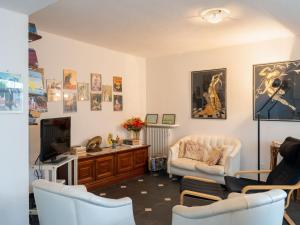 a living room with white chairs and a tv at Holiday Home Sara by Interhome in Alassio