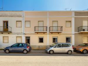 drie auto's geparkeerd voor een gebouw bij Holiday Home Magnolia by Interhome in Olhão