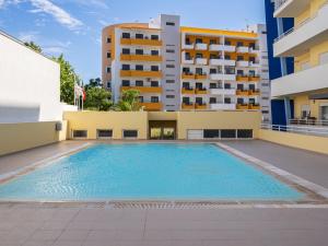 a swimming pool in front of a building at Apartment Capital 4 You by Interhome in Portimão