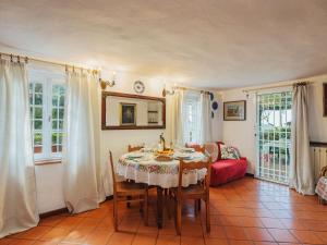 a dining room with a table and chairs and windows at Holiday Home Il Glicine by Interhome in Montemagno