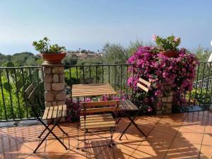 2 Stühle und ein Tisch auf einem Balkon mit Blumen in der Unterkunft Holiday Home Garden House Li Galli by Interhome in Torca