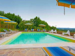 a swimming pool with tables and chairs and umbrellas at Holiday Home La Salamandra by Interhome in Montaione