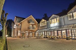 ein Gebäude mit Tischen und Stühlen in einem Innenhof bei Nacht in der Unterkunft Inklusions- und Panorama Hotel Kochsberg in Grebendorf