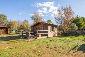 eine kleine Hütte auf einem Feld mit einem Zaun in der Unterkunft RANCH DU PUITS DE RIQUIER in Moissac-Bellevue