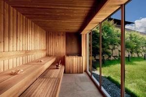 a sauna with a bench and a large window at ever grün KAPRUN inkl Zell am See-Kaprun Sommerkarte in Kaprun