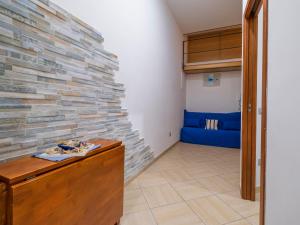 Pokój z kamienną ścianą i niebieską kanapą w obiekcie Apartment Sorrento Shore-Casa Mirta by Interhome w Sorrento