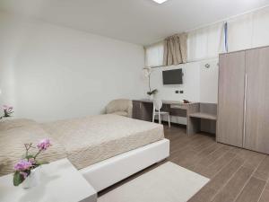 - une chambre avec un lit, un bureau et une télévision dans l'établissement Ferrari Hotel, à Carugate