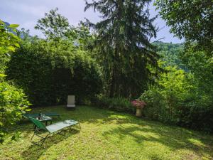 a garden with a table and a bench in the grass at Holiday Home Stella by Interhome in Stazzema