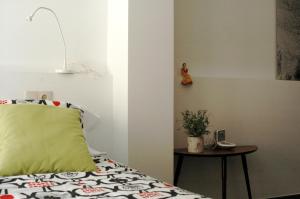Un dormitorio con una cama con una almohada verde y una mesa en El Terrat Sobre el Mercat, en La Seu d'Urgell