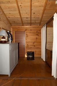 una cucina con pareti in legno e pavimenti in legno in una cabina di RANCH DU PUITS DE RIQUIER a Moissac-Bellevue