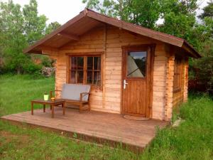 a small wooden cabin with a chair and a table at RANCH DU PUITS DE RIQUIER in Moissac-Bellevue