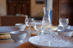 a table with glasses and bowls and plates on it at Ty coz kreisker in Pleyben