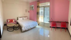 1 dormitorio con 1 cama, mesa y sillas en Kinmen Backpacker en Jincheng
