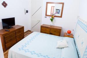 1 dormitorio con cama y vestidor con TV en Santa Restituta in Cagliari Centre Q4825, en Cagliari
