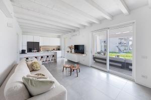 Sala de estar blanca con sofá y mesa en La Cittadella PT-6 by Wonderful Italy, en Manerba del Garda