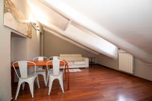 ein Esszimmer mit einem Tisch und weißen Stühlen in der Unterkunft San Salvario Apt with Balcony in Turin