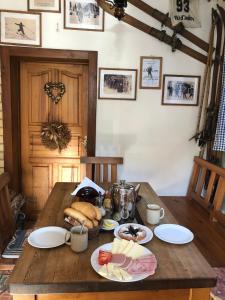 a wooden table with plates of food on it at Penzion ''Pod Hůreckým vrchem'' in Prášily