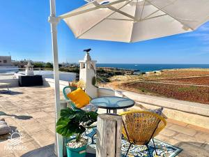 a patio with a table and an umbrella at Paradise Sea Terrace in Monopoli