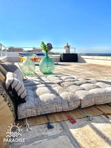 a couch with two vases sitting on top of a patio at Paradise Sea Terrace in Monopoli