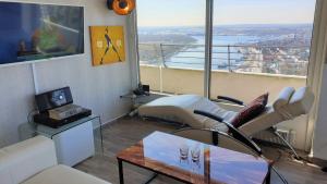 Un televizor și/sau centru de divertisment la Luxus-Ecksuite mit stylischem Design und Traumblick übers Meer, 26.Stock im Maritim