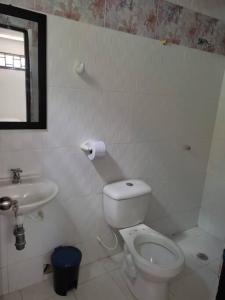 Baño blanco con aseo y lavamanos en Alojamiento entero, casa amplia, patio, aire, en Ríohacha