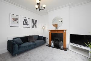 a living room with a couch and a television at Large Derby Cathedral Town House - Sleeps 8 w parking in Derby