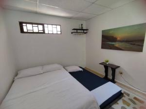 Un dormitorio con una cama y una mesa. en Alojamiento entero, casa amplia, patio, aire, en Ríohacha