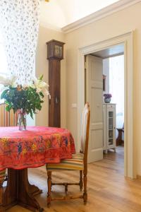 een eetkamer met een tafel en een vaas met bloemen bij Apartment Vespucci- quite Historic Palace in Florence