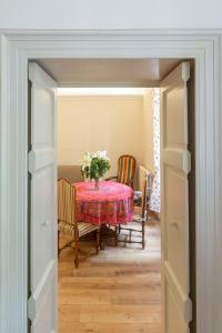 a dining room with a table with a vase of flowers at Apartment Vespucci- quite Historic Palace in Florence