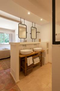 due lavandini in un bagno con due specchi di Domaine de la Xavolière a Saint-Cézaire-sur-Siagne
