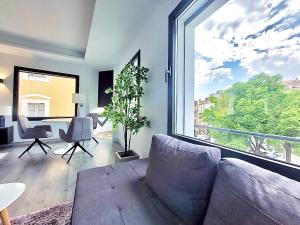 a living room with a couch and a large window at Plasencia Plaza Mayor Luxury in Plasencia