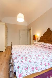 een slaapkamer met een groot bed met een sprei met bloemen bij Apartment Vespucci- quite Historic Palace in Florence +22 foto's