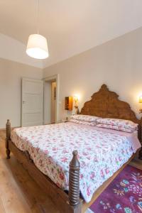 フィレンツェにあるApartment Vespucci- quite Historic Palaceのベッドルーム1室(花柄のベッドカバー付きの大型ベッド1台付)