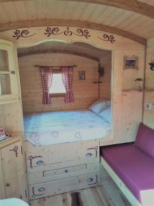 a small bedroom in a log cabin with a bed at Acabatz de dintrar in Brezons