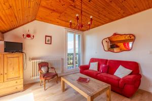 a living room with a red couch and a table at Appartement Pointe de la Sambuy in Trévignin
