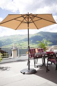 einen Tisch und Stühle mit Sonnenschirm auf dem Balkon in der Unterkunft Ferienwohnung Rust in Fendels