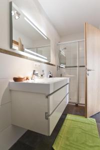 ein Badezimmer mit einem weißen Waschbecken und einem Spiegel in der Unterkunft Ferienwohnung Rust in Fendels