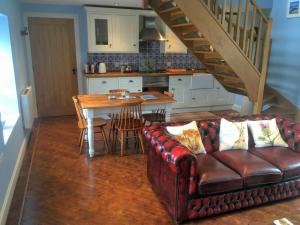 un soggiorno con divano e tavolo e una cucina di Cauldholm a Moffat