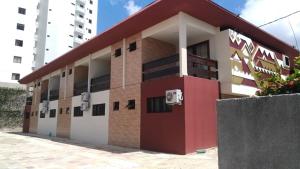 un edificio con una puerta roja delante de él en Pousada Ariús en Campina Grande