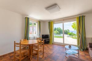 a living room with a table and chairs and a tv at Appartement Mont Colombier in Trévignin