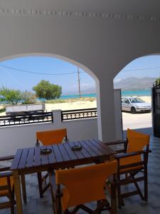a table and chairs in a room with a view of the beach at GIALOS Rooms in Elafonisos