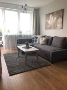 a living room with a couch and a coffee table at Apartament Wejhera Gdańsk Żabianka blisko morza in Gdańsk